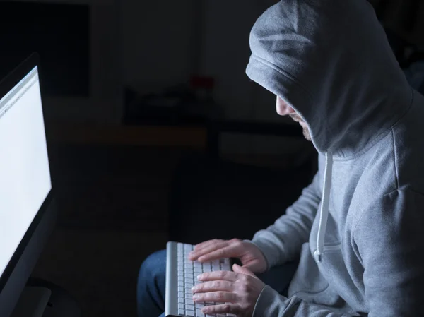 Porträtt av hacker i sitter framför datorn med glöd — Stockfoto