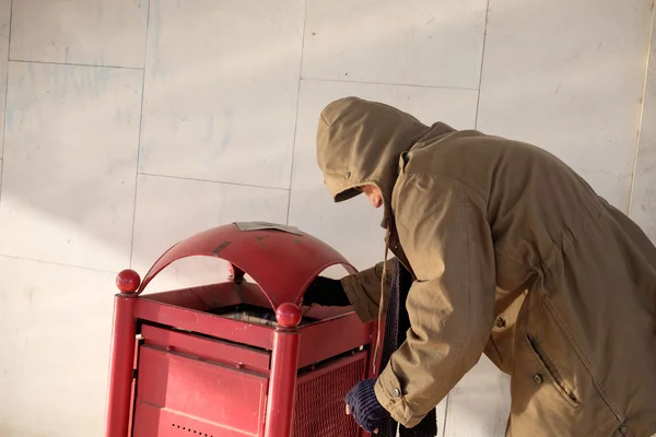 Homeless looking for food in the garbage bin — Stock Photo, Image