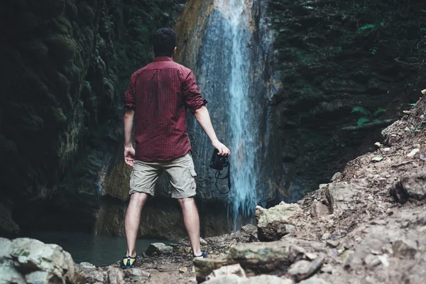 Mann nach Bergwanderung neben einem Wasserfall — Stockfoto