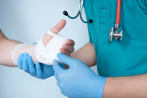 Bliska lekarza bandażowanie jedną ręką po wypadku — Zdjęcie stockowe