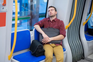 Yorgun banliyö metro koltukta uyuyor