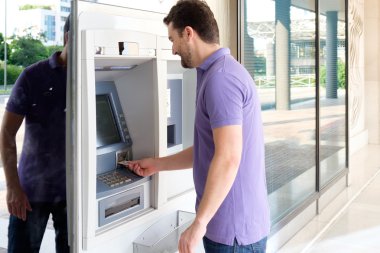 Kredi kartını bir atm nakit çekilmesi için kullanan adam