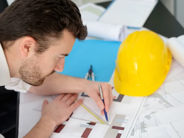 Architect working on his projects papers with compass — Stock Photo, Image