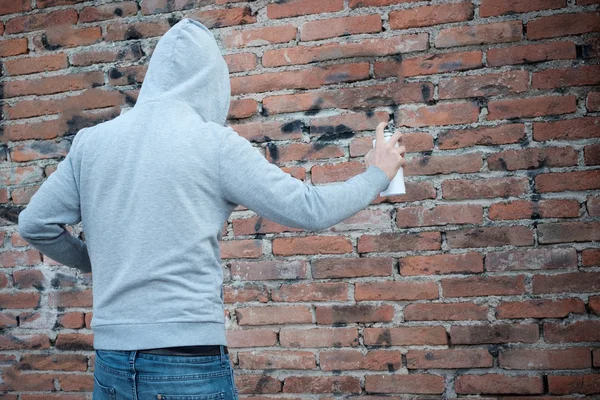 Hooded muzikale graffiti op stedelijke muren schrijven — Stockfoto