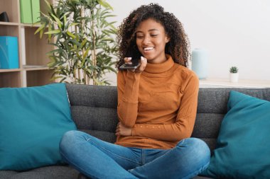 Sıradan bir genç siyahi kadın evde rahatlayıp akıllı telefondan mesaj atıyor.