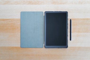Ahşap masada boş siyah ekranlı dijital tablet