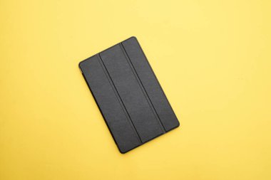 Sarı arkaplanda izole edilmiş dijital tablet kutusu.