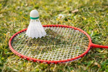 Shuttlecock ve badminton raket ekipmanları çimlerin üzerinde