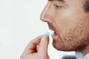 Bir adam ilaç kapsülü tedavisi görüyor.