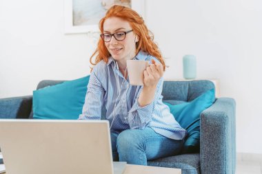 Evde çalışan kadın portresi dizüstü bilgisayar ve internet bağlantısı kullanıyor