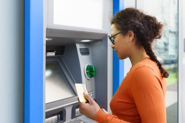 ATM 'den para çekerken siyahi bir kadın.