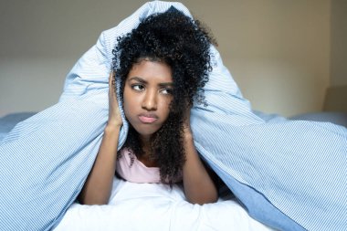 Pensive black woman trying to sleep in bed suffering from insomnia clipart