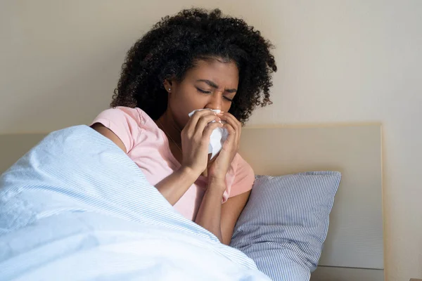 African woman portrait in bed feeling sick