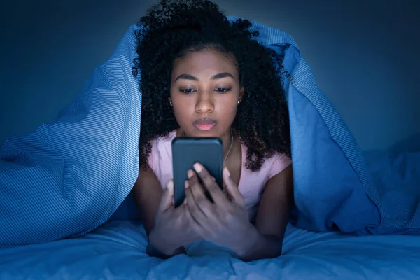 Mulher Sonolenta Deitada Cama Sob Cobertor Usando Smartphone Noite — Fotografia de Stock