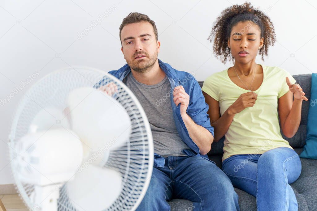 Mixed race couple trying to relief from summer heat wave
