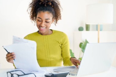 Uzaklık çalışması, e-öğrenme. Evde dizüstü bilgisayar kullanan bir kadın, internetten öğrenim görüyor.