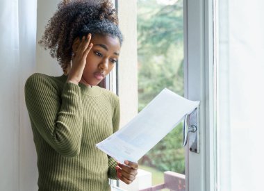 Sad depressed mixed race african american woman reading bad news clipart