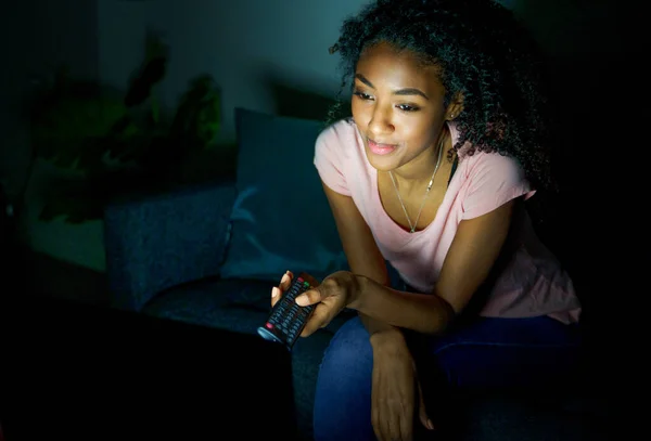 Black girl watching tv series at night at home