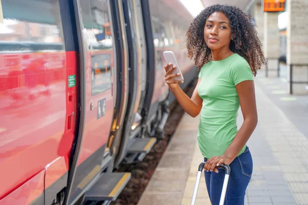 Afro Kobieta Gotowa Jazdy Pociągiem Trzymając Telefon Komórkowy — Zdjęcie stockowe