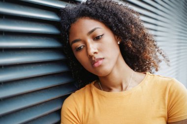 Üzgün ve üzgün hisseden yalnız siyah bir genç kadın