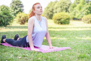 One woman in sportswear doing stretching outdoor in the park