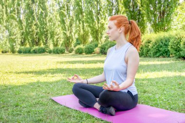 One young woman in lotus position during yoga lesson
