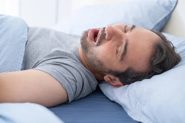 One man falling asleep and snoring in bed