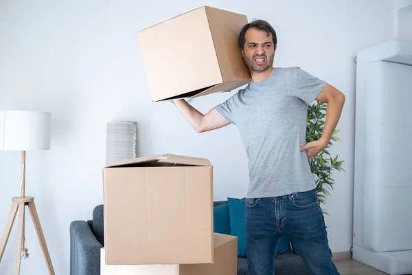 Άντρας Που Σηκώνει Κουτιά Και Μετακομίζει Στο Νέο Σπίτι Υποφέρει — Φωτογραφία Αρχείου