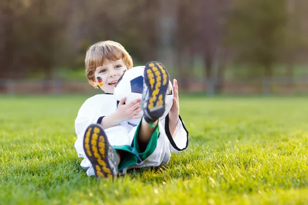 Мальчик играет в футбол с футболом — стоковое фото
