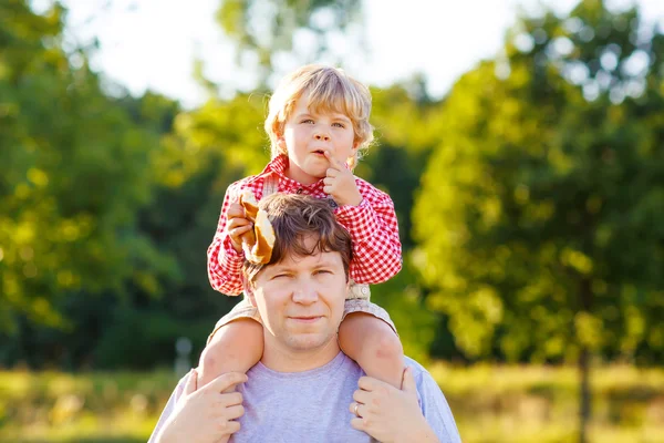 Unga far och hans lille son att ha kul på gula hö sätter jag — Stockfoto