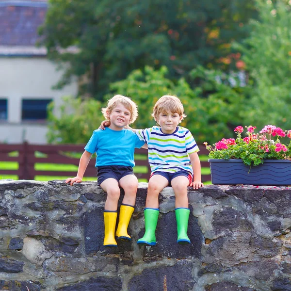 Two little kid boys sitting together on stone bridge — Stock Photo, Image