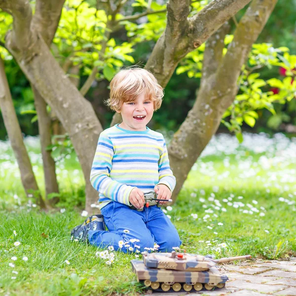 Cute little child playing with toy tank — Stock Fotó