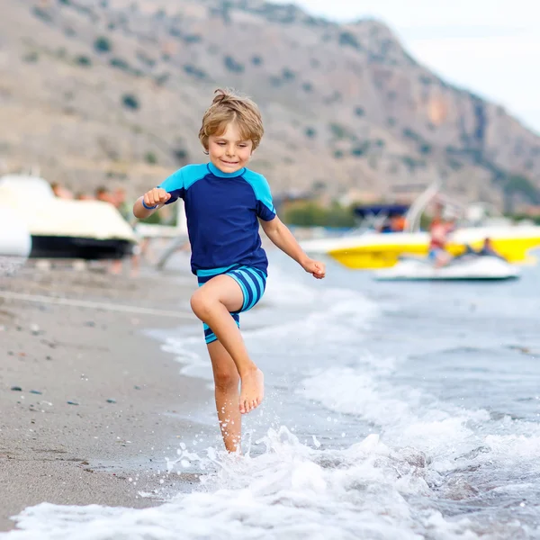 Menino loiro pequeno menino correndo praia oceano — Fotografia de Stock