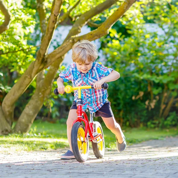 Jongen jongen, driewieler of fiets rijden in tuin — Stockfoto