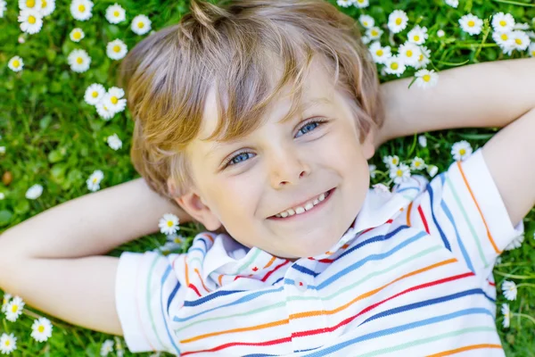 Glad liten pojke om på grönt gräs på sommaren — Stockfoto