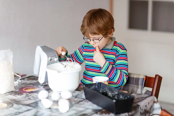 Divertente ragazzo biondo che cuoce torta al chiuso — Foto Stock