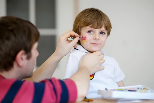 Padre pittura bandiera sul viso del bambino per il calcio o socce — Foto Stock