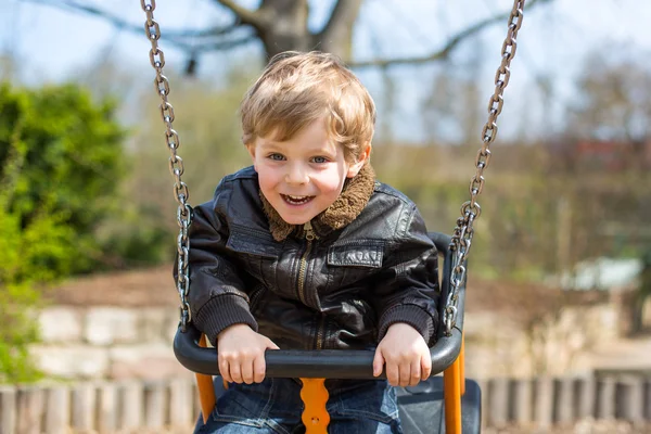 Funny toddler boy having fun on swing — Stock Photo, Image