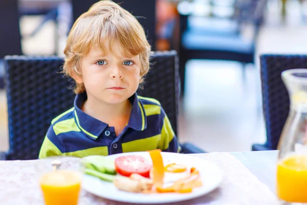Liten unge pojke med hälsosam frukost i restaurang — Stockfoto