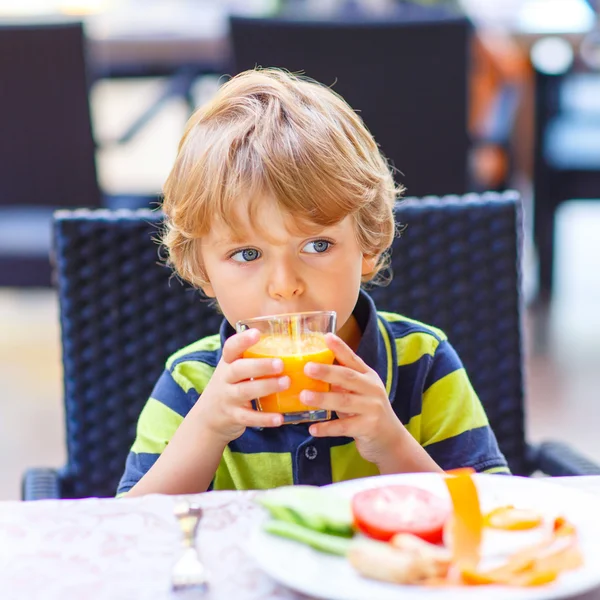 Liten unge pojke med hälsosam frukost i restaurang — Stockfoto