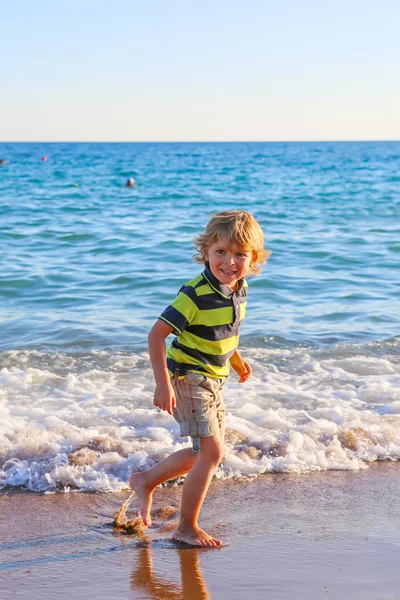 Happy little kid boy having fun with running through water in oc — Stock Photo, Image