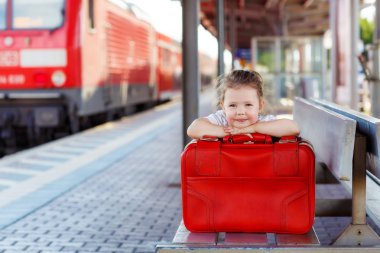 büyük kırmızı bavul bir tren istasyonu ile küçük kız