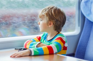 Little boy sitting in train and going on vacations