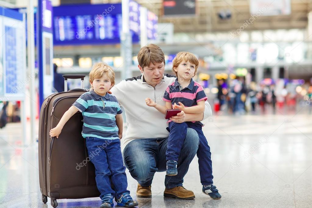 Father and two little sibling boys at the airport