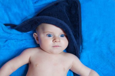 Küçük çocuk oğlu mavi banyo havlusu karşı