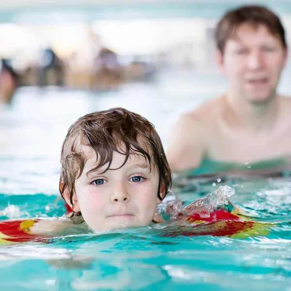 Jonge vader onderwijs zijn zoontje te zwemmen binnenshuis — Stockfoto