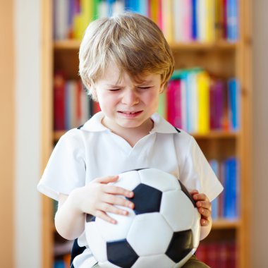 Kid boy sad about lost football or soccer game clipart