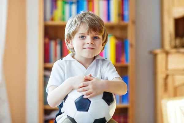 Liten pojke tittar på fotboll eller fotbollsmatch på tv — Stockfoto