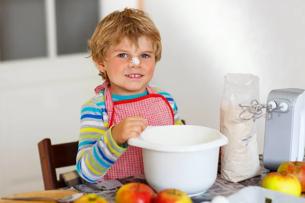 Divertente ragazzo biondo che cuoce torta di mele al chiuso — Foto Stock