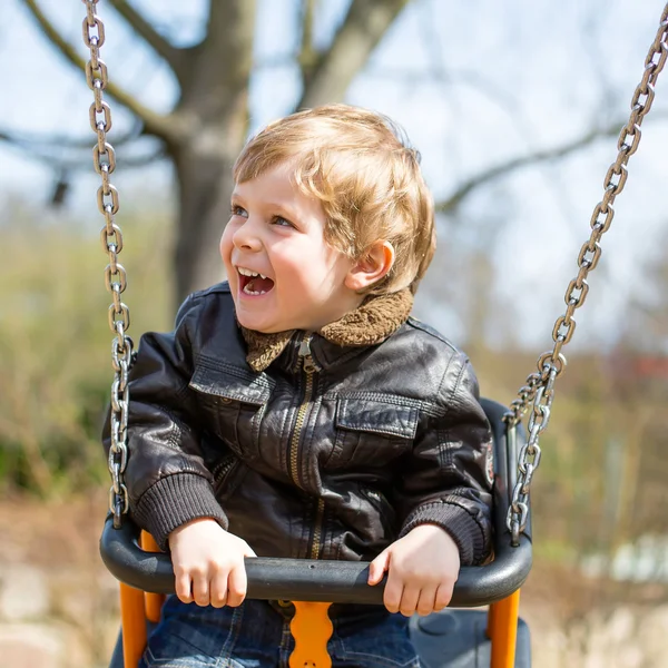 Funny toddler boy having fun on swing — Stock Photo, Image